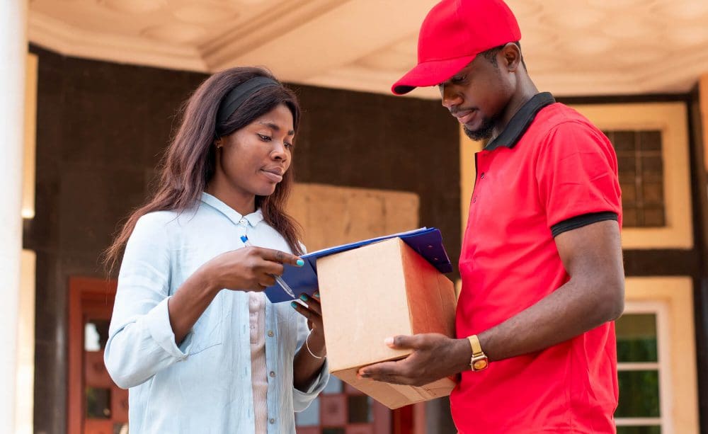 A woman and man holding boxes in front of them.